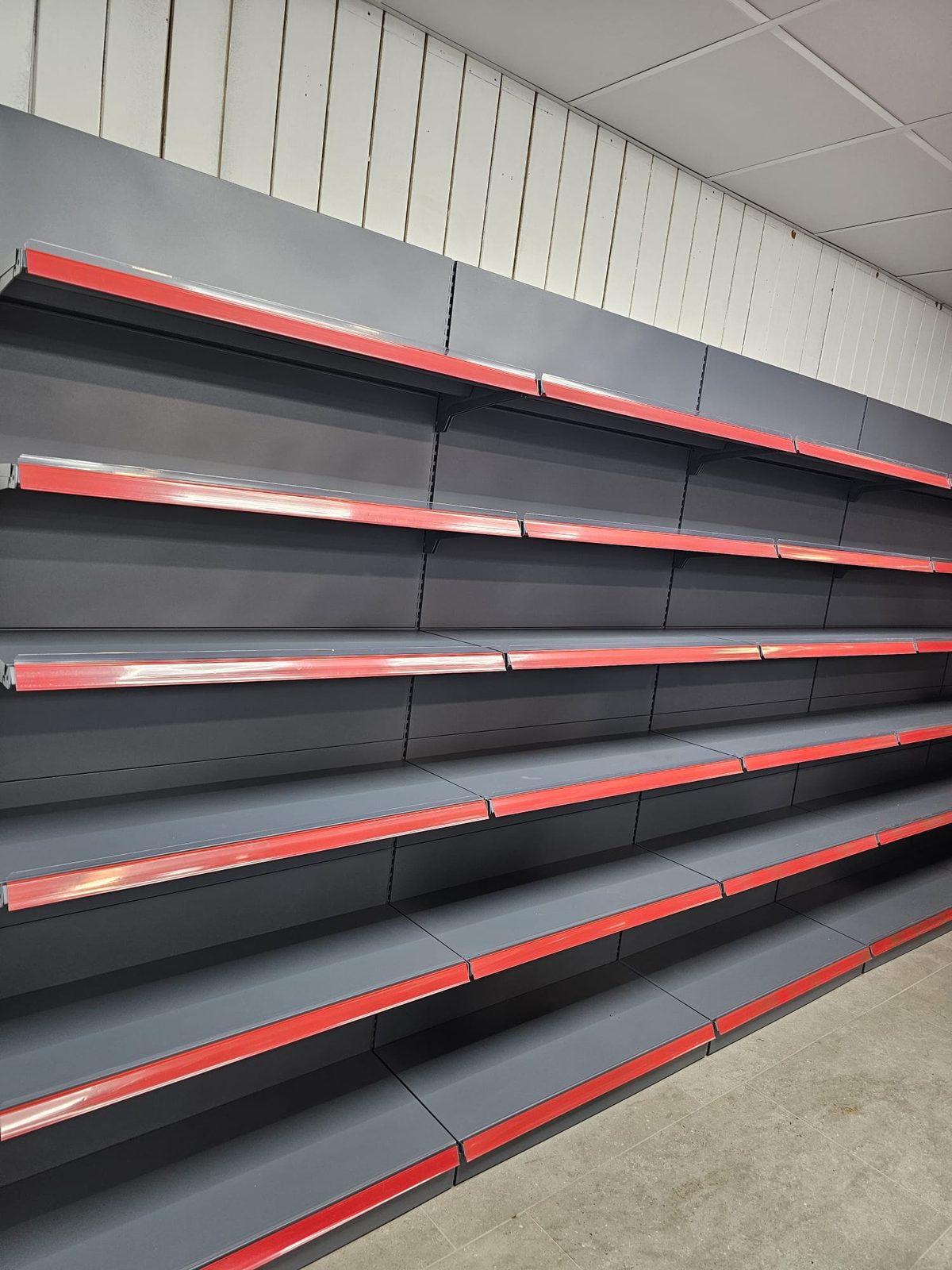 Wall bay shelving with red price rails